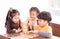 Three kids eating delivery pizza in classroom