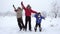 Three kids jumping together on winter landscape, slow motion