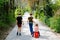 Three kids, little toddler girl and two kid boys walking in park pandemic coronavirus disease. Children, lovely siblings
