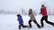 Three kids running together on winter landscape, slow motion