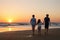 Three kids silhouettes running and jumping on beach at sunset. happy family, two school boys and one little preschool