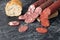 three kind of different sausages on a cutting board near bread. Pieces of sausage cut into circles on a black background