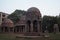 Three kiosk standing on pillars of pink sandstones in a garden and green trees in Houz Khas Complex, Delhi, India