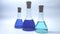 three laboratory conical test tubes with blue liquid