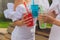 Three ladies cheering with tasty nectars with ice cubes, with black straws, palms decoration, in swim pool, transparent