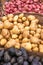 Three large baskets of purple, yellow and red potatoes