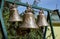 Three large metal bells. Church bells are hanging. The inscription on the bell - Ñ…Ð²Ð°Ð»Ð¸Ñ‚ - praise.