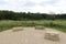 Three large stone slabs for resting at the end of the trail surrounded by wildflowers and grasses and trees in Illinois