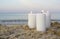 Three large white paraffin candles burn on sand beach background sea