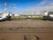 Three large white powerful fast planes with turbines, wings and screws are parked near the aircraft hangars on the runway