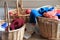 Three large wood baskets filled with apples, knitting needles and colorful yarn