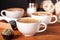 Three latte cups and small cakes on the wooden table in the cafe. Communication over a Cup of coffee, Coffee break