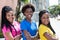 Three laughing african american girlfriends in line in the city