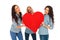 Three laughing casual women holding a big red heart