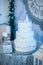 Three-layer white holiday cake on the table decorated with fir trees and gift box