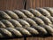 Three layers of stretched cordage on a wooden background. The fibers of the rope are tightly and neatly twisted and create rhythm