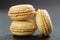 Three lemon macarons on slate board