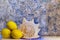 Three lemons and a seashell on a table with lights. White and blue background texture. Copy space