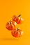 Three levitating ceramic pumpkins on orange background. Vertical Halloween banner