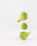 Three levitating ripening green figs.