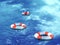 Three lifebuoys, floating on waves