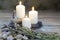 Three lighted candles with lavender on wooden table and herbal background