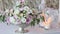 Three lighting candles and bouquet of roses on wedding table