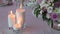 Three lighting candles and bouquet of roses on wedding table