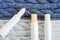 Three lip balms on the knitted background. Winter lip care sticks with beeswax, honey, panthenol and shea butter. Copy space