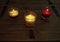 Three lit autumn candles on pine table