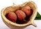 Three litchi fruits in a wooden container