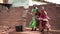 Three little African girls pumping water at the community well