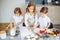 Three little chefs enjoying in the kitchen making big mess. Kids making cookies in the kitchen