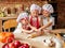 Three little chefs enjoying in the kitchen making cakes. Girls at the kitchen. Family housekeeping