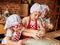 Three little chefs enjoying in the kitchen making cakes. Girls at the kitchen. Family housekeeping