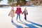 Three little girl friends learn to skate. Outdoor recreation an