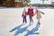 Three little girl friends learn to skate. Outdoor recreation and holidays