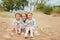 Three little girls are adorable sisters hugging on the background of the sea in windy summer weather