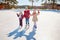 Three little girls skate on the ice. Vacations and holidays in n