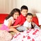 Three little Latino brothers have fun together and share quality time very happily between laughs, kisses and hugs between pillows