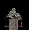 Three little owls perched on a wooden post isolated on a black background