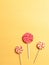 Three lollipops on a yellow background. minimal concept. sugar sweets.