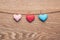 Three love hearts hanging on wooden texture background