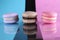 Three macaroons on a blue black pink background different colors different tastes with place for text and reflection