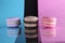 Three macaroons on a blue black pink background different colors different tastes with place for text and reflection