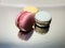 Three macaroons pink, blue, yellow lying on the flat surface