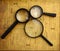 Three Magnifying glasses on vintage newspaper background.