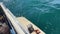 Three male fishermen catch fish with a fishing rod in the turquoise waters of Avacha Bay