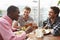 Three Male Friends Enjoying Lunch At Rooftop Restaurant