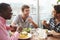 Three Male Friends Enjoying Lunch At Rooftop Restaurant